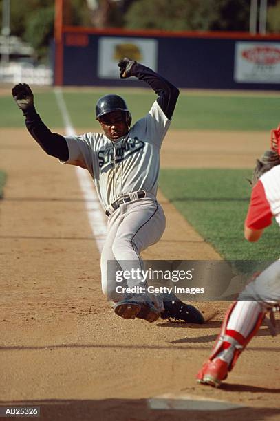 baseball player sliding to home base - base sports equipment stockfoto's en -beelden