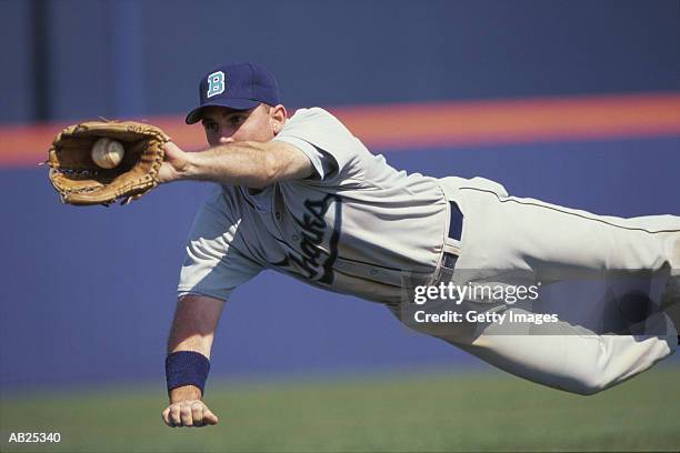 baseball infielder diving to catch ball - vangershandschoen stockfoto's en -beelden