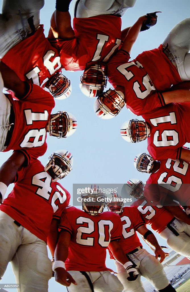 Football team in huddle, low angle view