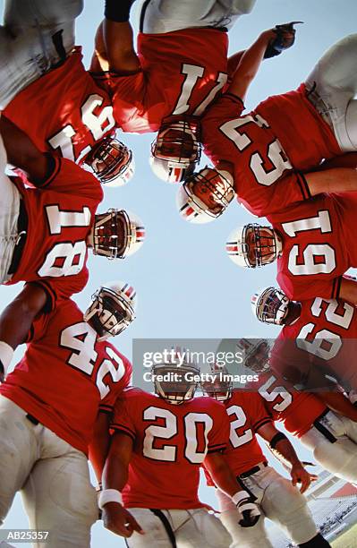 football team in huddle, low angle view - abrazo de grupo fotografías e imágenes de stock