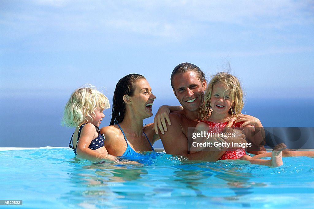 Family in pool, daughters (2-4)