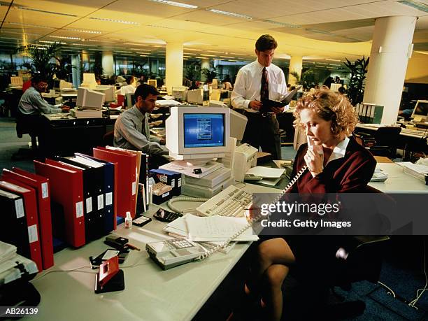 general office scene with woman on the phone - general images of commuters as australia employment figures are released stockfoto's en -beelden