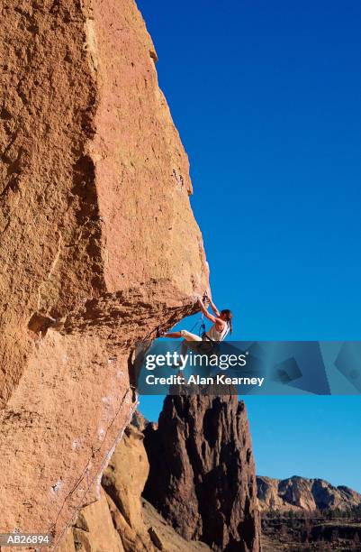 woman climbing rock overhang - rock overhang stock pictures, royalty-free photos & images