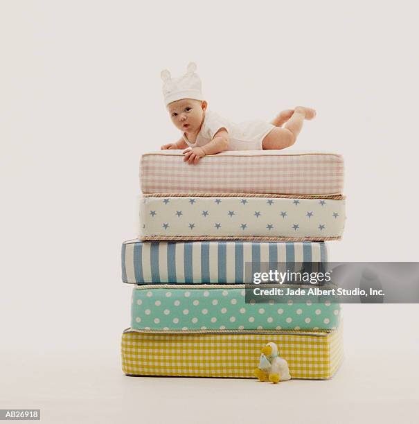 baby (3-6 months) lying on stack of mattresses - albert foto e immagini stock