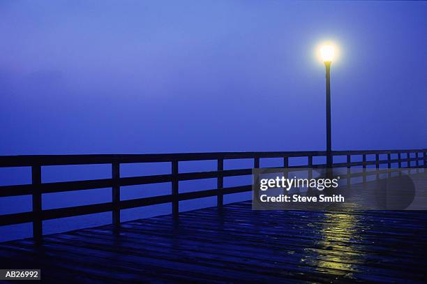 light shining on pier, night - seal beach stock pictures, royalty-free photos & images