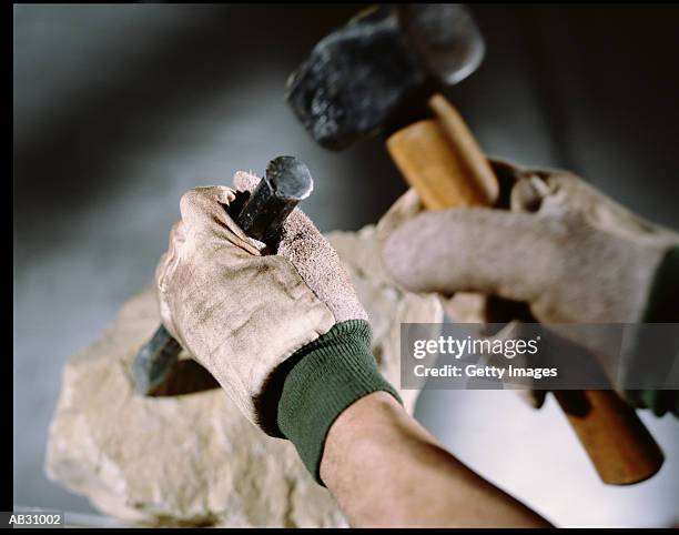 man chipping rock with hammer and chisel - ouvrier maçon photos et images de collection