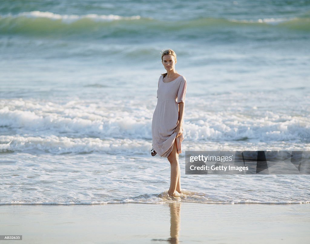 Woman standing at water's edge at beach