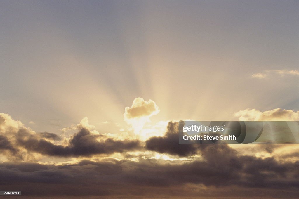 Sun behind dark clouds, sunrise