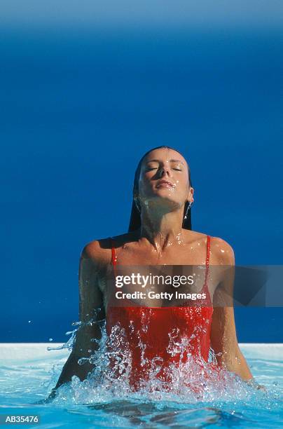 woman emerging from swimming pool - eendelig zwempak stockfoto's en -beelden