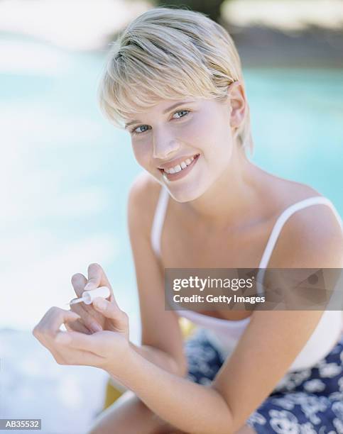 Woman Sitting By Swimming Pool Painting Nails Portrait High-Res Stock Photo