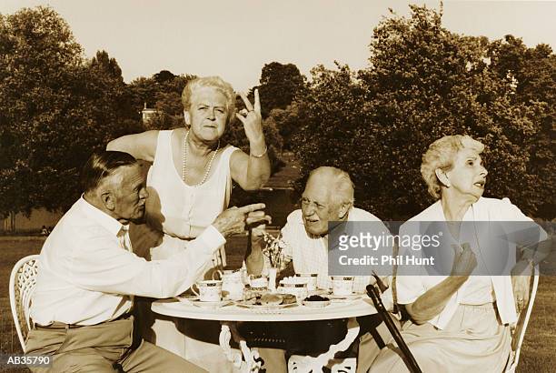 two elderly couples making gestures at table in garden b/w - phil stock pictures, royalty-free photos & images