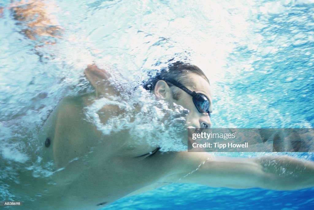 Man swimming underwater, close up