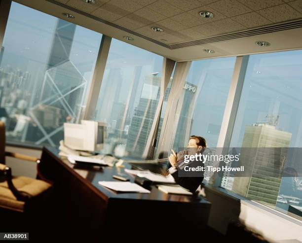 businessman talking on telephone in office - corner office stock pictures, royalty-free photos & images