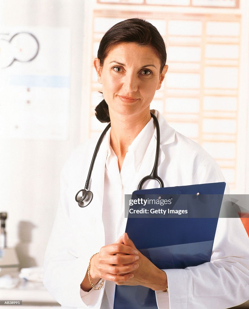 Female doctor holding clipboard, portrait