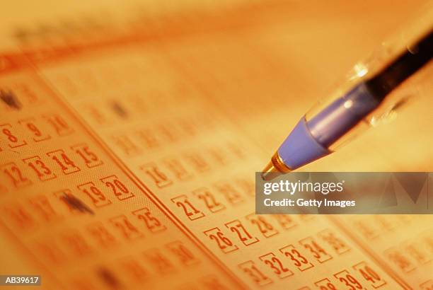 pen marking numbers on form, close-up - loterij stockfoto's en -beelden