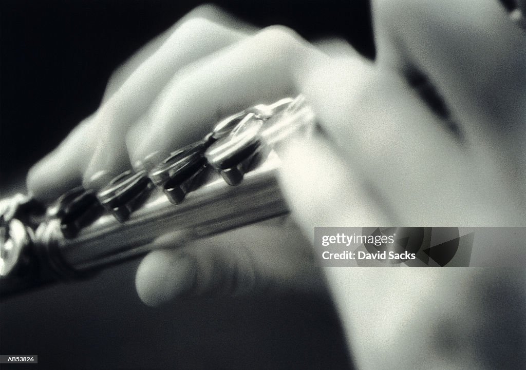 Person playing flute, close-up (B&W)