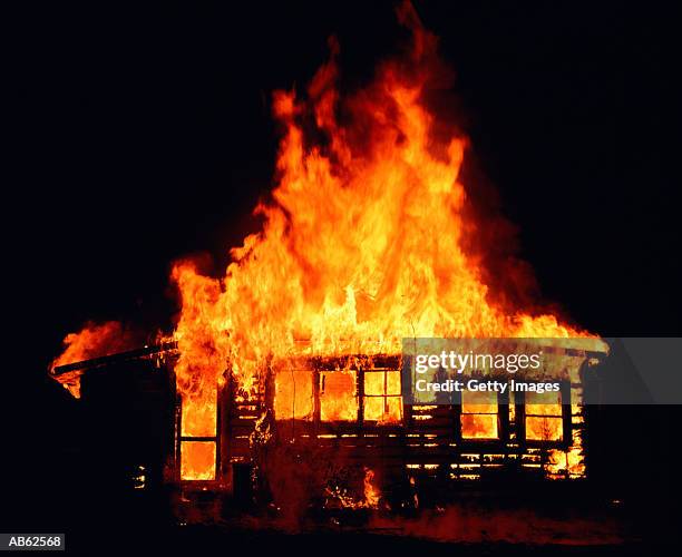 house on fire at night - burning stockfoto's en -beelden