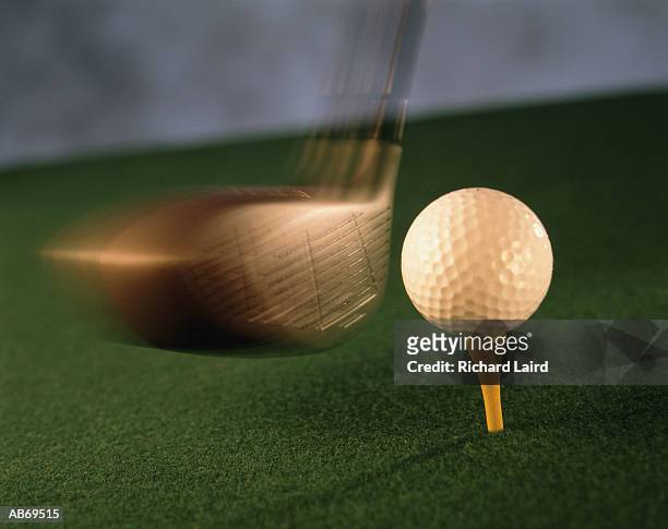 golf club striking ball on tee, close-up (blurred motion) - golf swing close up stock pictures, royalty-free photos & images