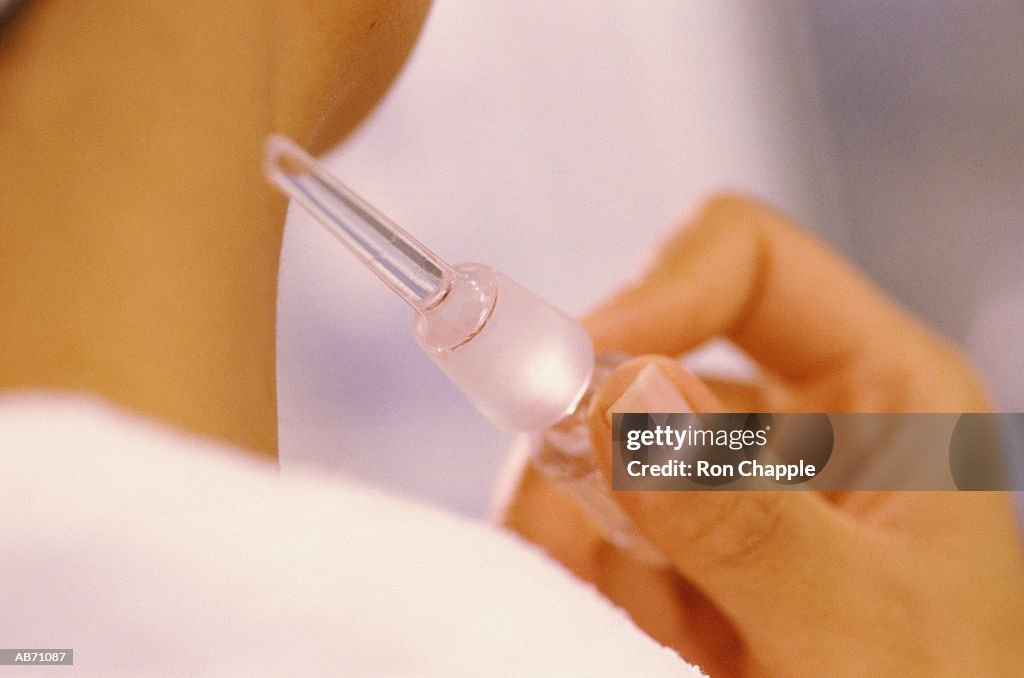 Woman applying perfume to arm, close-up