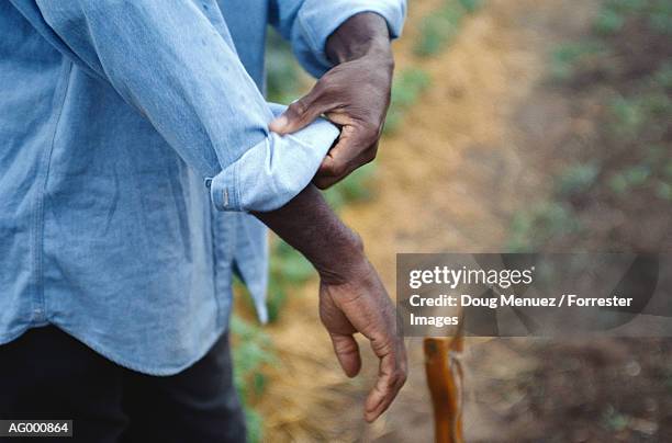 man rolling up his sleeves - rolling stockfoto's en -beelden