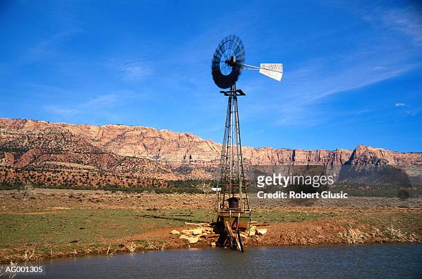 windmill by river - 工業用風車 ストックフォトと画像