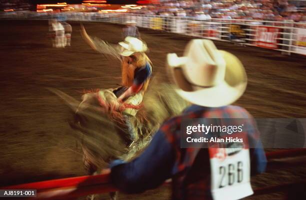 man riding bull at rodeo, blurred action - bull riding stockfoto's en -beelden