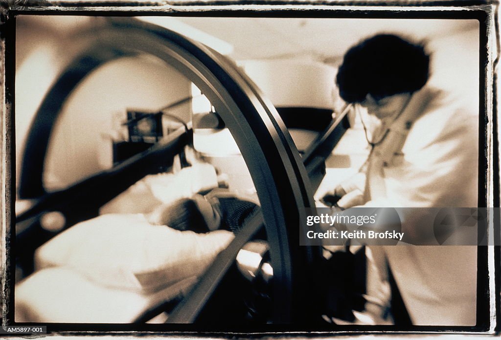 Nurse conducting tests on patient using Gamma Camera (toned B&W)
