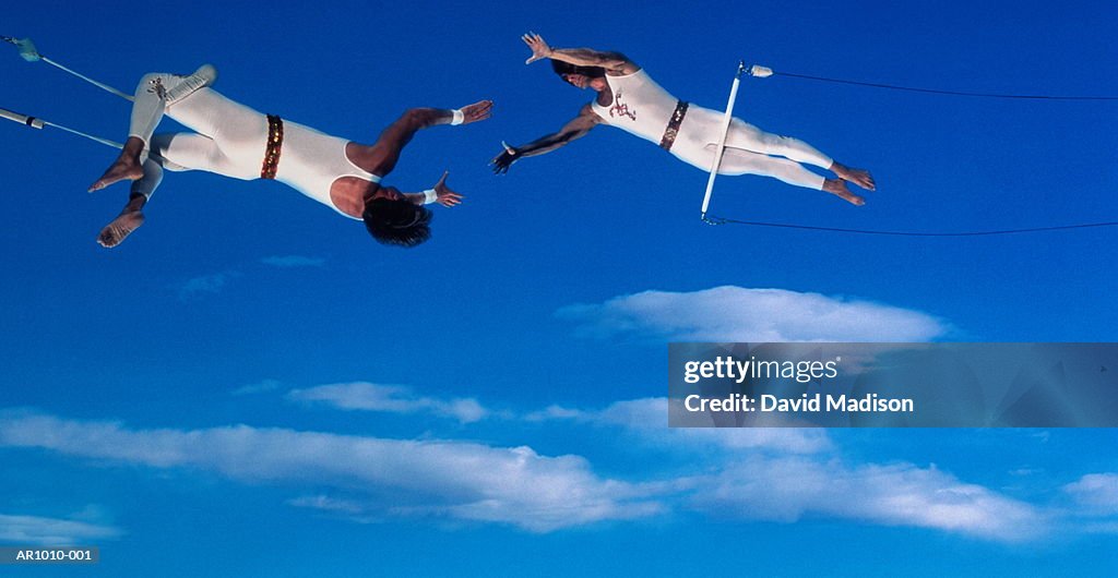 Trapeze artists performing release move (Digital Composite)