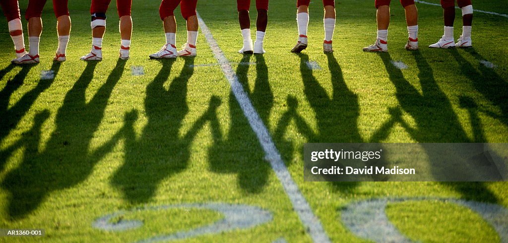 Legs of American football players on field, (Digital Enhancement)