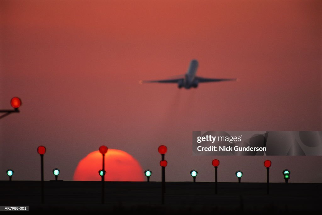 McDonnell Douglas MD-80 jet taking off in flight at sunset