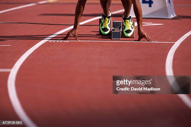 female athlete at start of race, low section (digital enhancement) - athletics track stock pictures, royalty-free photos & images