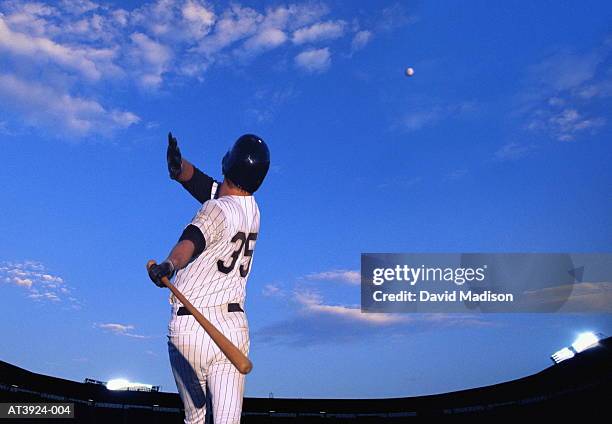 baseball player hitting ball out of stadium, rear view (composite) - battere la palla foto e immagini stock