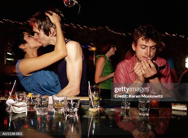 young couple kissing in bar, man smoking, glasses in foreground - bar tender photos et images de collection