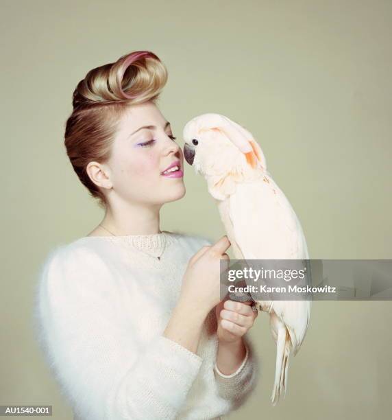 young woman petting cockatoo, portrait (brightly lit) - bird portraits stock pictures, royalty-free photos & images