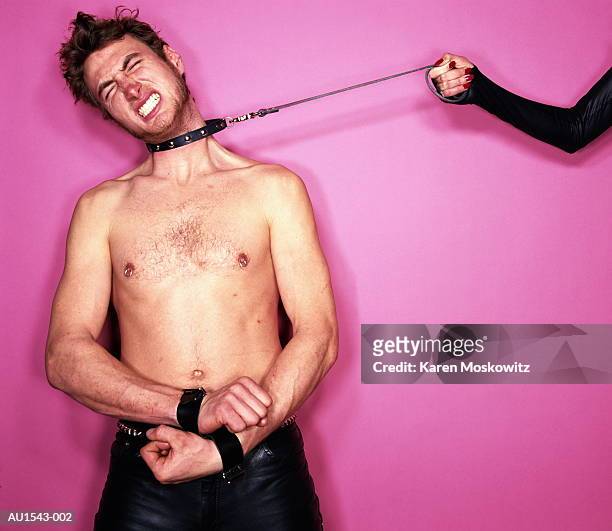 young man wearing leather collar, woman pulling leash - s & m stock-fotos und bilder