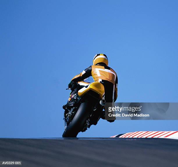 motorcyclist leaning into turn, rear view - motorrace stockfoto's en -beelden