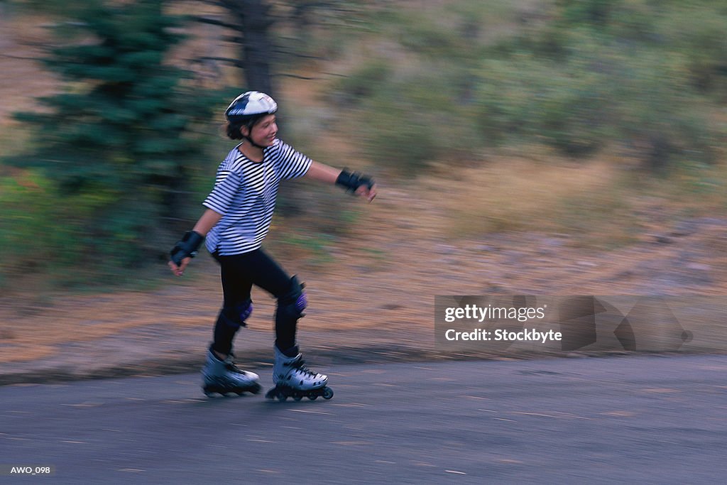 Woman in-line skating along road