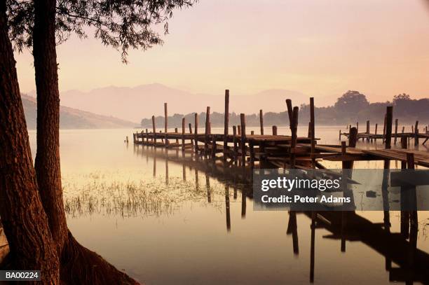 jetty into lake panajchel at sunset / guatemala - sunset lake imagens e fotografias de stock