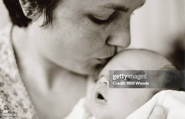 mother kissing newborn baby (0-3 months) on forehead, close-up (b&w) - 0 1 mes fotografías e imágenes de stock