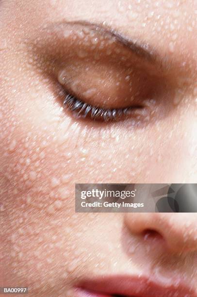 woman with eyes closed with water on face, close-up - skincare stockfoto's en -beelden