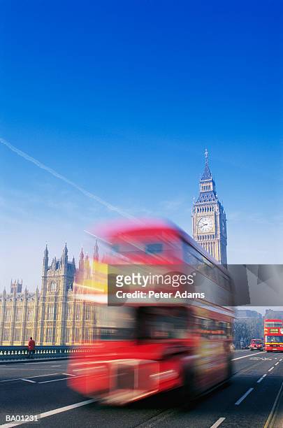 red double-decker bus driving past big ben (blurred motion) - decker stock pictures, royalty-free photos & images
