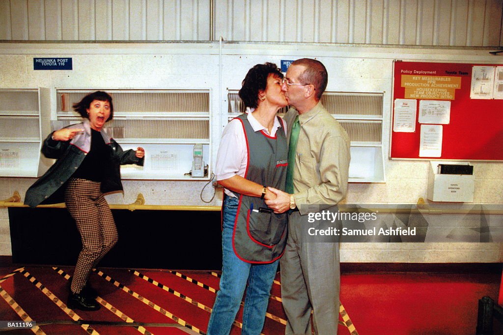 Female worker catching colleagues kissing