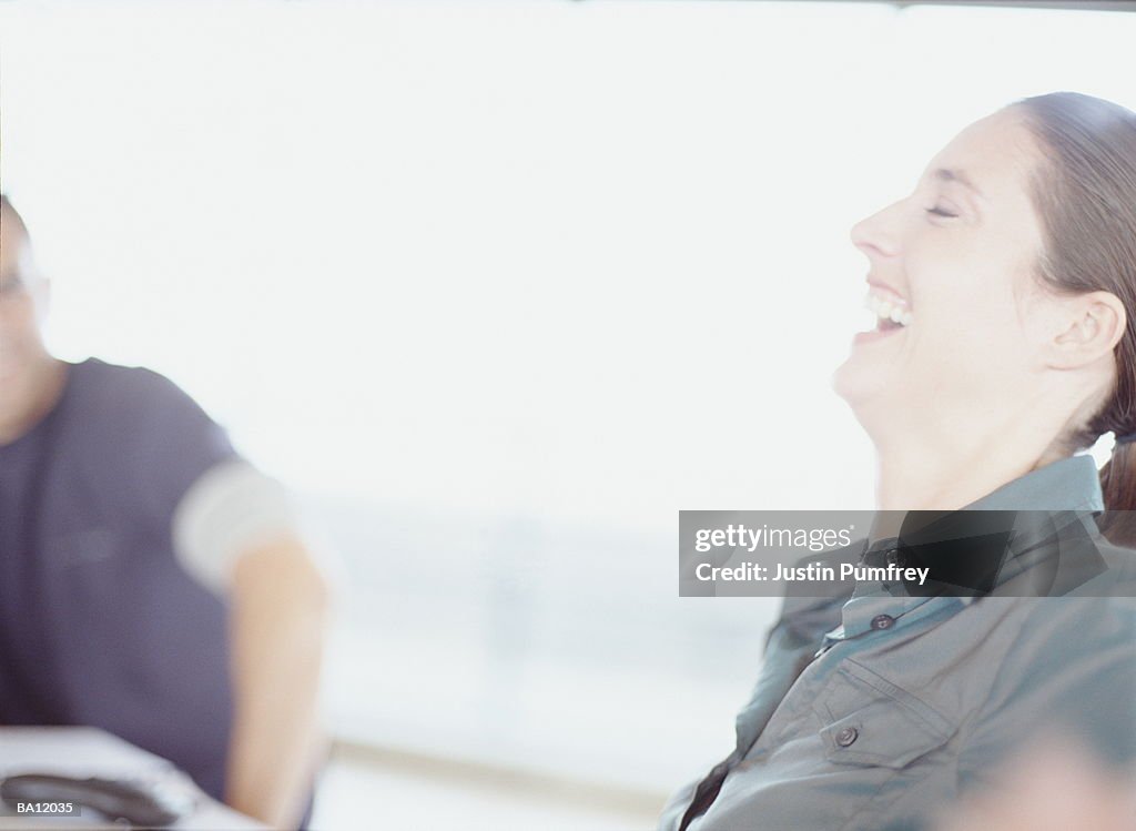 Woman laughing with head thrown back and eyes closed, profile