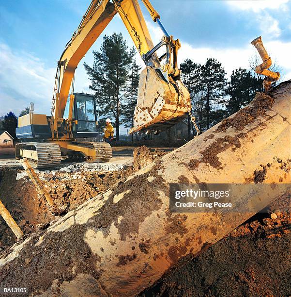 bulldozer removing underground storage tank - greg pease stock pictures, royalty-free photos & images