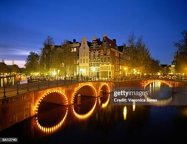 netherland, north holland, amsterdam, illuminated bridge over canal - the netherland stock pictures, royalty-free photos & images