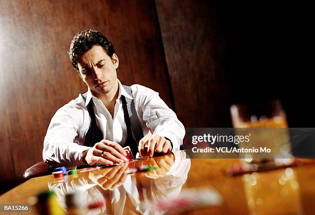 man lifting playing cards on table - antonio stock pictures, royalty-free photos & images