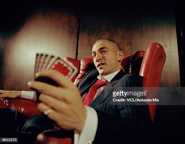 man in leather chair, holding playing cards, close up - antonio stock pictures, royalty-free photos & images