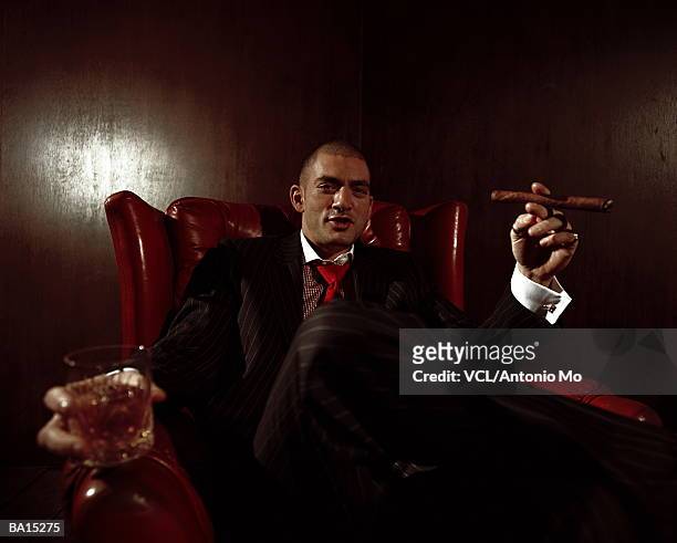 man in leather chair, holding drink and cigar, portrait - antonio stock pictures, royalty-free photos & images