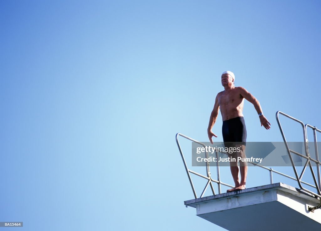 Mature man preparing to dive off platform