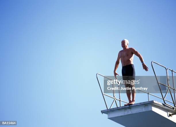 mature man preparing to dive off platform - diving platform stock pictures, royalty-free photos & images
